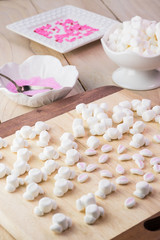 Cut marshmallows for easter bunny cake decoration.