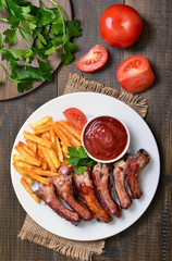 Grilled pork ribs, vegetables, potato fries and tomato sauce