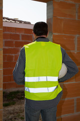 Construction worker with white helmet looking at the new building