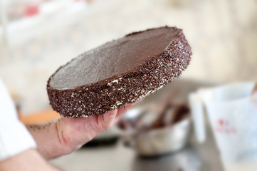 Baker Carrying Chocolate Cake in Bakery