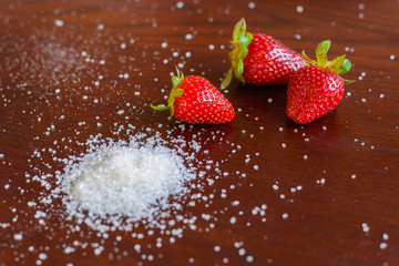red jucy strawberry with white sugar on the table