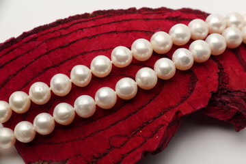 Pearls on the wooden background/Wooden heart on driftwood mahogany with pearls on the background.