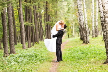 Fototapeta na wymiar Beautiful Romantic Wedding Couple Kissing and Embracing Outdoors