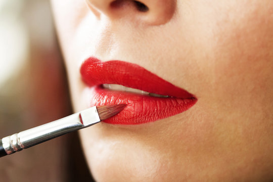 Lip makeup, red lipstick, lipstick brush, beautiful young brunette woman doing makeup