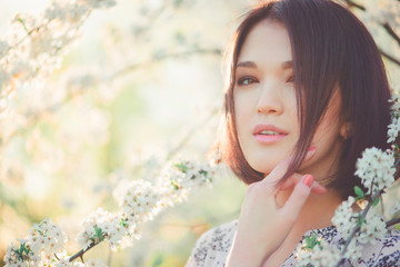 Cherry blossoms. Spring beauty girl outdoors. Blooming trees. Romantic young woman portrait. Sakura - 106499027