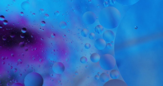 Oil drops floating in water over a colorful underground with oil painting effect. Shot on RED
