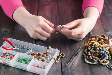 Woman making beaded bracelet with her hands