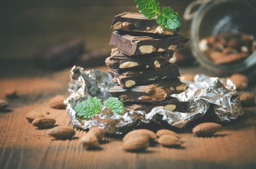 Broken chocolate bar, mint leaves and almonds