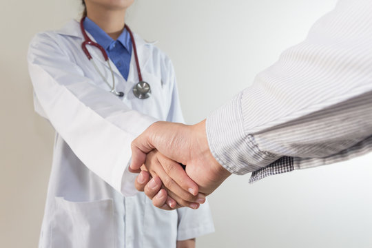 Woman doctor shakes hands with a patient
