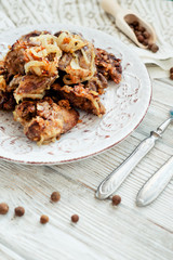 
Fried chicken liver with onions and spices on a wooden background