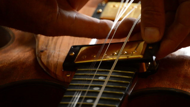 Luthier placing an electric guitar pickup in the workshop