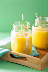 healthy mango pineapple smoothie in mason jars
