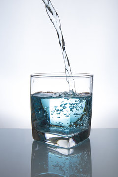 Concept of drinking. Pouring water from into glass