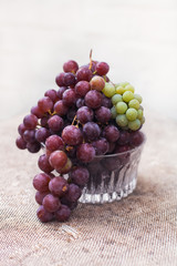 Fresh green and blue  grapes in a crystal vase.  Rustic style.