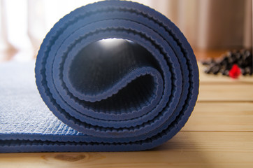 Fototapeta na wymiar Closeup of blue yoga mat on wooden background