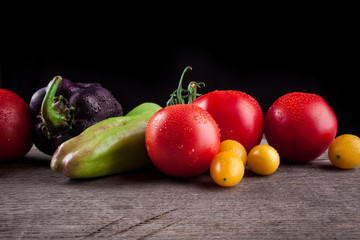 vegetables on a black background, peppers, tomatoes
