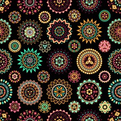 Seamless pattern of bright colorful geometric round ethnic decorative elements. Vector mandala background with bohemian, Oriental, Indian, Arabic, Aztec motifs.