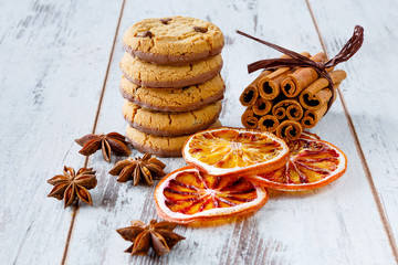 Chocolate cookies with dry oranges, anise and cinnamon on the light wooden boards