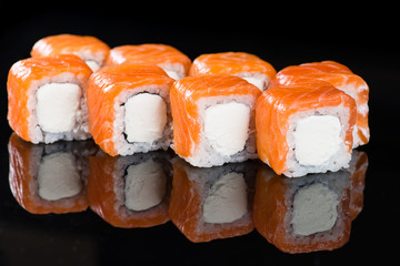 Sushi Roll with salmon over  black background with reflection