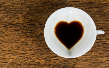 heart shape of black Coffee cup on wooden table