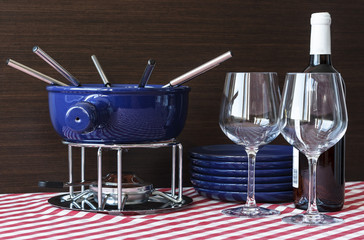 Special set of utensils for cooking fondue and white wine with two glasses