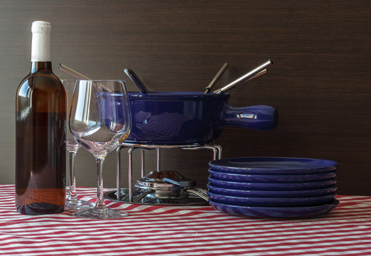 Special set of utensils for cooking fondue and white wine with two glasses