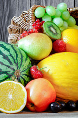 Sommerfrüchte mit Korb vor Holzhintergrund