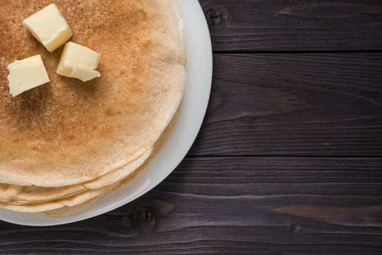 pancakes with butter on a wooden background