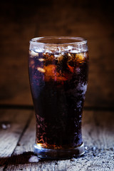Cola with crushed ice in a big sweaty glass, dark toned image, s