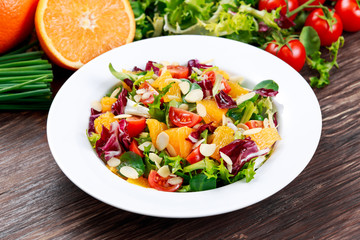 Fresh Orange, vegetables salad. on wooden table.