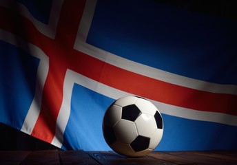 Naklejka premium Flag of Iceland with football on wooden boards as the background.