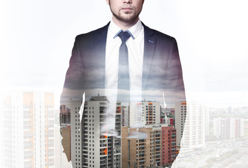 Double exposure of modern city and businessman wearing an elegant suit, standing with his hands in pockets 