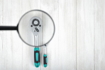 Top view of construction tools under magnifier on wooden DIY workbench.