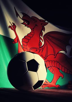 Flag of Wales with football on wooden boards as the background. Vintage style.