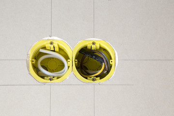 Два жёлтых подрозеточника установленных в гипсокартоне
