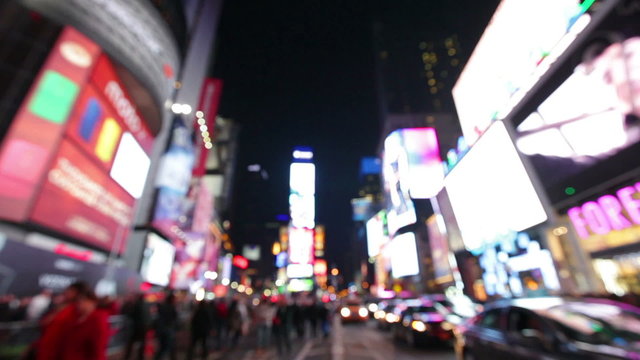 Times Square, New York City, Manhattan background out of focus with blurry unfocused city lights and billboards. City at night with cars and pedestrians people walking.