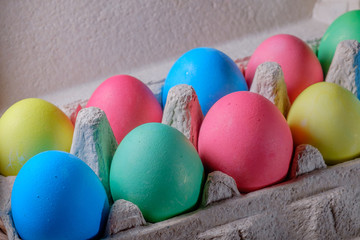 Fototapeta na wymiar Красивые пасхальные яйца разных цветов на свеьлом фоне