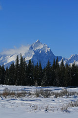 Lone Grand Teton peak with snow mist blowing off in Wyoming United States