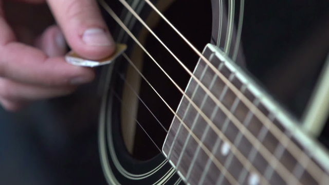 Guitar strings strummed with a pick at 240 fps.