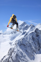 Fototapeta na wymiar Snowboard jump on mountains. Extreme winter sport.