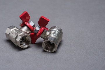 Water valves with red handle on grey