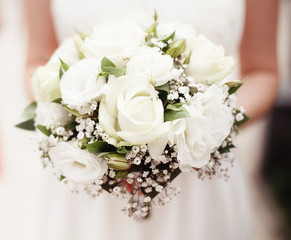 Bride holding bouquet of white roses