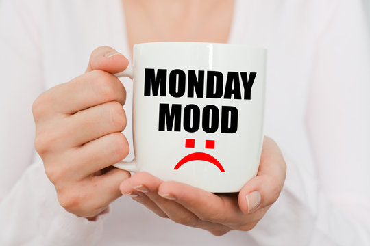 Monday Mood With Sad Symbol On White Coffee Cup Held By A Woman