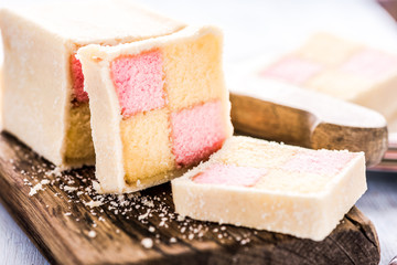 slicing Battenberg homemade sponge cake