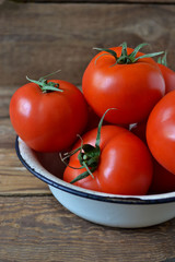 Fresh, juicy, red tomatoes on a wooden background