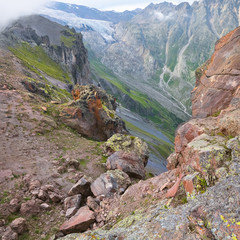 Tourist among the rocks on the background of the glacier