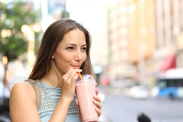 Foto auf Acrylglas Milchshake Frau isst einen Milchshake auf der Straße