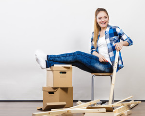 Woman moving into apartment assembly furniture.