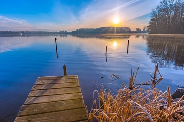 Fototapeta premium Sunrise over lake at end of winter