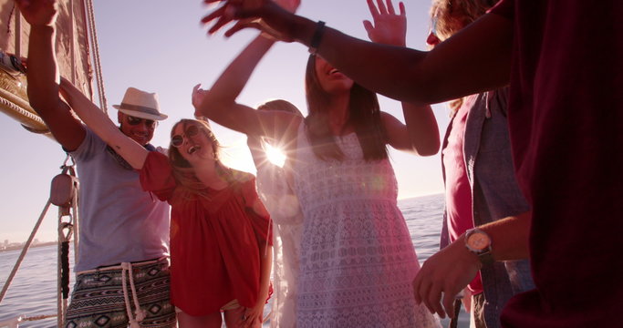 mixed race Group of friends dancing at sunset yacht party